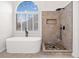Spa-like bathroom with a luxurious tub, walk-in shower and neutral-tone tile at 1007 Fairway Seven, Villa Rica, GA 30180