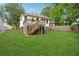 Backyard view of a two-story home featuring a wooden deck with stairs and a large grass area at 1792 Center Ave, East Point, GA 30344