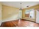 Spacious living room featuring hardwood floors, large window, and traditional chandelier at 1792 Center Ave, East Point, GA 30344