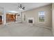 Living room view to kitchen includes a fireplace, neutral paint, and a ceiling fan at 3039 Tuscan Ridge Dr, Snellville, GA 30039