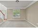 Neutral-toned living room with plush carpeting, a large window, and a staircase to the second level at 3039 Tuscan Ridge Dr, Snellville, GA 30039