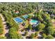 Stunning aerial view of community amenities including tennis courts, pool, playground, and clubhouse surrounded by lush trees at 5725 Lake Oak Lndg, Cumming, GA 30040