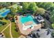 Aerial view of community pool and clubhouse featuring palm trees and lounge seating at 5725 Lake Oak Lndg, Cumming, GA 30040
