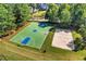 Aerial view of basketball and sand volleyball courts amid lush green grass and mature trees at 5725 Lake Oak Lndg, Cumming, GA 30040