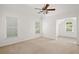 Bright, spacious bedroom with neutral carpet, a ceiling fan, and natural light from the three windows at 5725 Lake Oak Lndg, Cumming, GA 30040