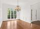 Spacious dining room boasts hardwood floors, traditional chandelier and generous natural light at 5725 Lake Oak Lndg, Cumming, GA 30040