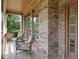 Inviting front porch with brick facade, framed by large windows, and cozy seating area at 5725 Lake Oak Lndg, Cumming, GA 30040
