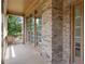Charming front porch featuring brick facade, and natural wood door with windows and trim at 5725 Lake Oak Lndg, Cumming, GA 30040