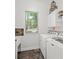 Laundry room features a sink, washer and dryer, white cabinets, a window, and tile floors at 5725 Lake Oak Lndg, Cumming, GA 30040