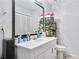Bright bathroom featuring a black-framed mirror and a white vanity with ample storage at 6057 Dorchester Dr, Rex, GA 30273