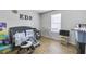 Bright bedroom with wood floor, and a dark gray crib and playpen with an ironing board at 6057 Dorchester Dr, Rex, GA 30273