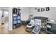 Bright bedroom with wood floor, and a dark gray crib and playpen, with a black shelving unit at 6057 Dorchester Dr, Rex, GA 30273