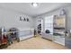 Light-filled bedroom featuring a white crib, hardwood floors, and built in storage and display shelving at 6057 Dorchester Dr, Rex, GA 30273