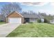 Charming single Gathering home featuring an attached two car garage and well-manicured front lawn at 6057 Dorchester Dr, Rex, GA 30273