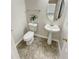 Modern bathroom with a pedestal sink, toilet, and a decorative houseplant at 1371 Blazing Star Rd, Lawrenceville, GA 30045
