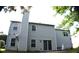 View of the two-story home's vinyl siding and chimney from the backyard at 1371 Blazing Star Rd, Lawrenceville, GA 30045