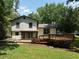 The backyard features a lush green lawn and wooden deck and lots of space for activities at 2442 Falcon Ct, Lawrenceville, GA 30043