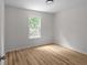 Bright bedroom with hardwood floors and a large window showcasing the outdoor view at 2442 Falcon Ct, Lawrenceville, GA 30043