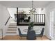 Dining area with glass table, modern lighting, and stairs leading to the living room at 2442 Falcon Ct, Lawrenceville, GA 30043