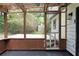 A screened-in porch area with wood floors and wooden support beams offers views of the green yard at 2442 Falcon Ct, Lawrenceville, GA 30043