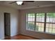 Bedroom with hardwood floors, a ceiling fan, and a large window overlooking the backyard at 282 Ellesmere Court, Buford, GA 30518