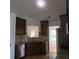 Well-lit kitchen featuring granite countertops, stainless steel appliances, and dark wood cabinetry at 282 Ellesmere Court, Buford, GA 30518