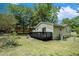 Serene backyard featuring a dark deck, grassy lawn, and a backdrop of mature trees, perfect for relaxation and outdoor enjoyment at 376 Pine Ne St, Marietta, GA 30060