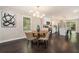 Dining area with hardwood floors and modern lighting, flowing into a stylish kitchen with white cabinetry at 376 Pine Ne St, Marietta, GA 30060