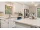 A close up of the bright kitchen features white cabinets, stainless steel appliances, and island with bar seating at 376 Pine Ne St, Marietta, GA 30060
