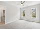 Spacious bedroom with plush carpet, ceiling fan, and two bright windows offering natural light at 8210 Sonata Ln, Cumming, GA 30041