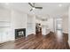 Open-concept living room with a fireplace, hardwood floors, and a view into the kitchen at 8210 Sonata Ln, Cumming, GA 30041