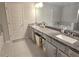 Bathroom with granite counters, double sinks, tiled floor, and gray cabinets at 2264 Shetley Creek Dr, Norcross, GA 30071