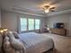 Bright bedroom with a tray ceiling, ceiling fan, a large window, and wooden furniture at 2264 Shetley Creek Dr, Norcross, GA 30071