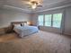 Large bedroom with a tray ceiling, three windows, and neutral carpeting throughout at 2264 Shetley Creek Dr, Norcross, GA 30071