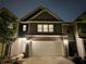 Townhome exterior with two-car garage, landscaping, and neutral color scheme at nighttime at 2264 Shetley Creek Dr, Norcross, GA 30071