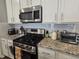 Close up of kitchen features with stainless steel appliances, granite counters, and white subway tile at 2264 Shetley Creek Dr, Norcross, GA 30071