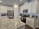 Well-lit kitchen with stainless steel appliances, granite countertops, and white cabinets at 2264 Shetley Creek Dr, Norcross, GA 30071
