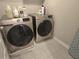 Modern laundry room features front loading washer and dryer and gray tile floors at 2264 Shetley Creek Dr, Norcross, GA 30071