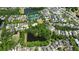 Aerial view showcasing a residential neighborhood with amenities, surrounded by a lush green landscape and a tranquil lake at 6715 Pond Rd, Cumming, GA 30040