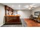 Basement wet bar featuring beautiful wood accents, tile flooring, and two leather chairs at 6715 Pond Rd, Cumming, GA 30040