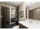 Bathroom featuring a glass door shower, dark tile, neutral paint, and a white granite countertop at 6715 Pond Rd, Cumming, GA 30040