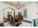 Bright dining room boasts coffered ceilings, wood floors, elegant chandelier, and access to a side room with a piano at 6715 Pond Rd, Cumming, GA 30040