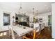 Open-concept dining area with a wooden table, chandelier, and view into the kitchen at 6715 Pond Rd, Cumming, GA 30040