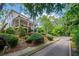 Two-story home with a covered front porch is surrounded by lush landscaping and mature trees on a sunny day at 6715 Pond Rd, Cumming, GA 30040