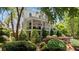 Beautiful two-story house boasts a covered front porch with an American flag and manicured landscaping at 6715 Pond Rd, Cumming, GA 30040