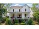 Charming white home featuring a covered front porch with columns and an American flag at 6715 Pond Rd, Cumming, GA 30040