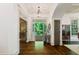 Bright foyer with hardwood floors and an open doorway looking out to a green, landscaped front yard at 6715 Pond Rd, Cumming, GA 30040