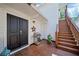 Inviting entryway with double doors, stainless steel grill, and wooden stairs to upper level of home at 6715 Pond Rd, Cumming, GA 30040