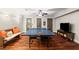 Recreation room with ping pong table, TV, and wood floors, perfect for entertaining guests at 6715 Pond Rd, Cumming, GA 30040