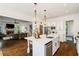 Open-concept kitchen with island, stainless appliances, and seamless flow into the living room at 6715 Pond Rd, Cumming, GA 30040